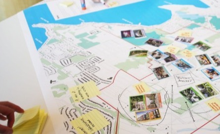 Community engagement event where people are writing over a map with ideas