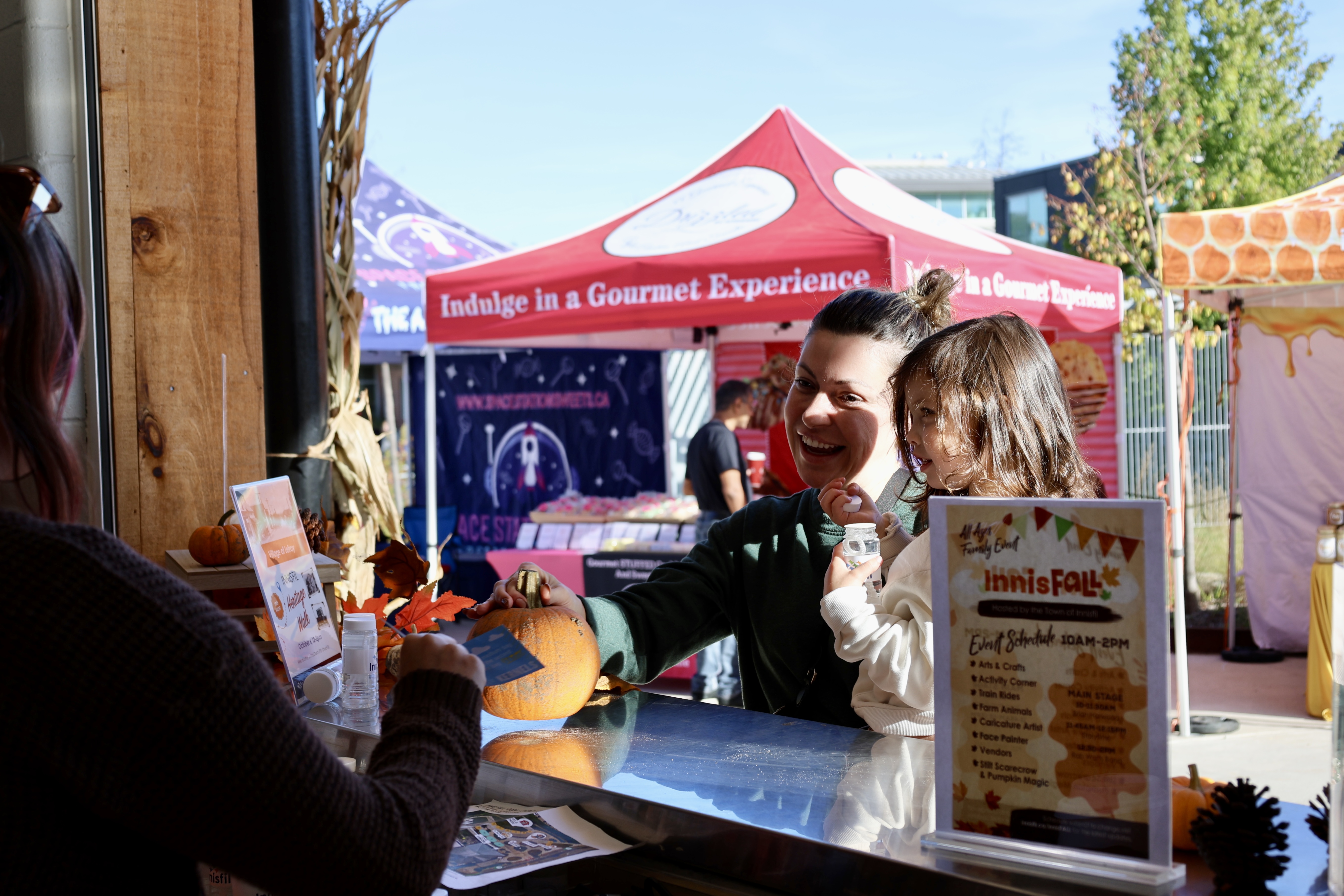 Family purchasing goods from a vendor at the InnisFALL event.