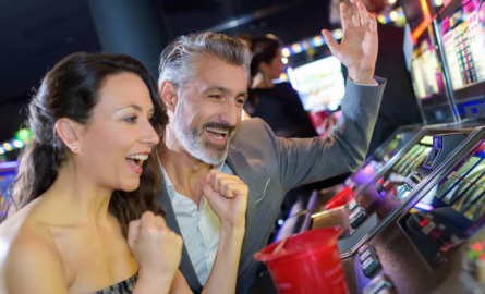 A couple celebrating a slot machine win at a casino