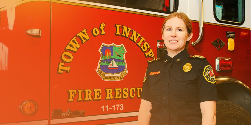 Smiling deputy fire chief standing in front of fire truck