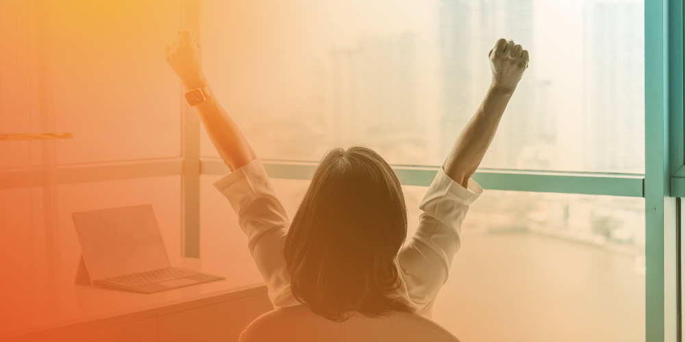 Happy business woman sitting in chair with arms stretched out