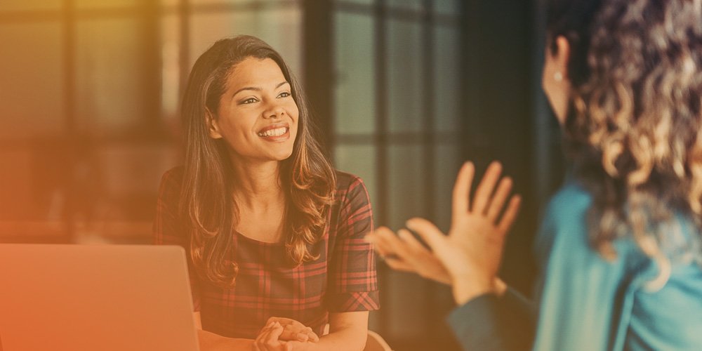 two employees having a conversation and smiling