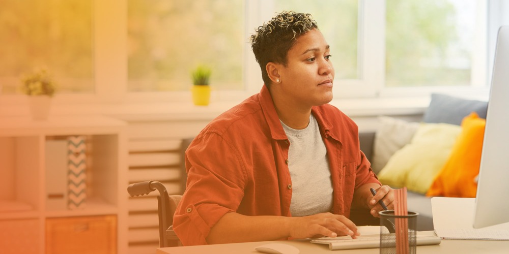 Woman in wheelchair using computer at work