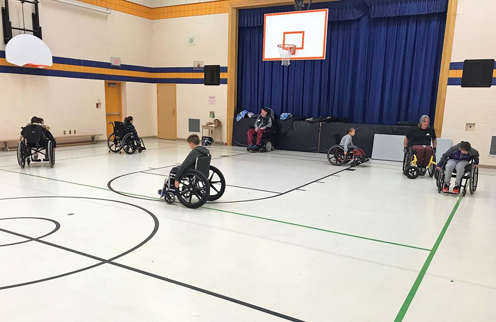 Students learning about the use of a wheelchair