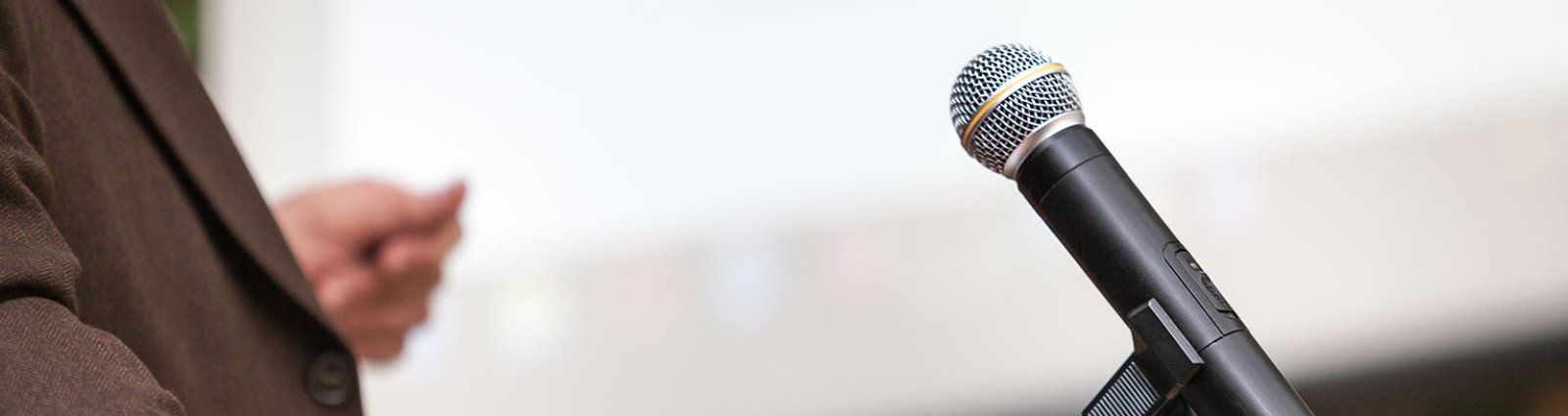 Close up of a person reaching for a microphone