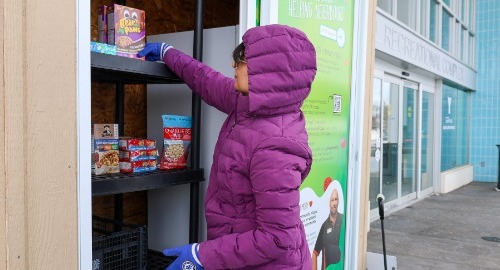 Person putting items into the community fridge