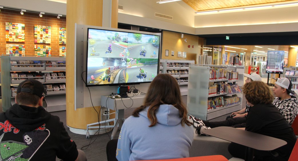 Teens playing video games at library