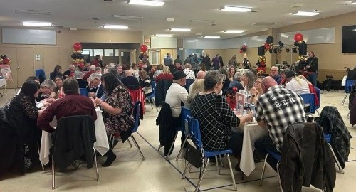 People sitting at tables and eating at Legion Dance