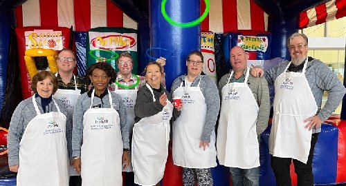 Council members wearing cooking aprons