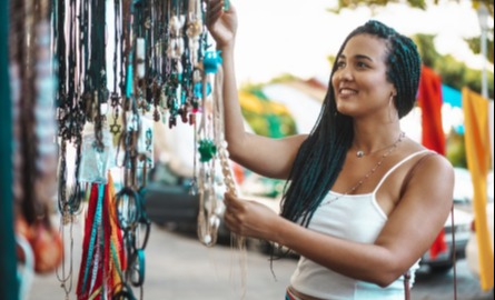 Black woman looking and choosing crafts at pop up shop