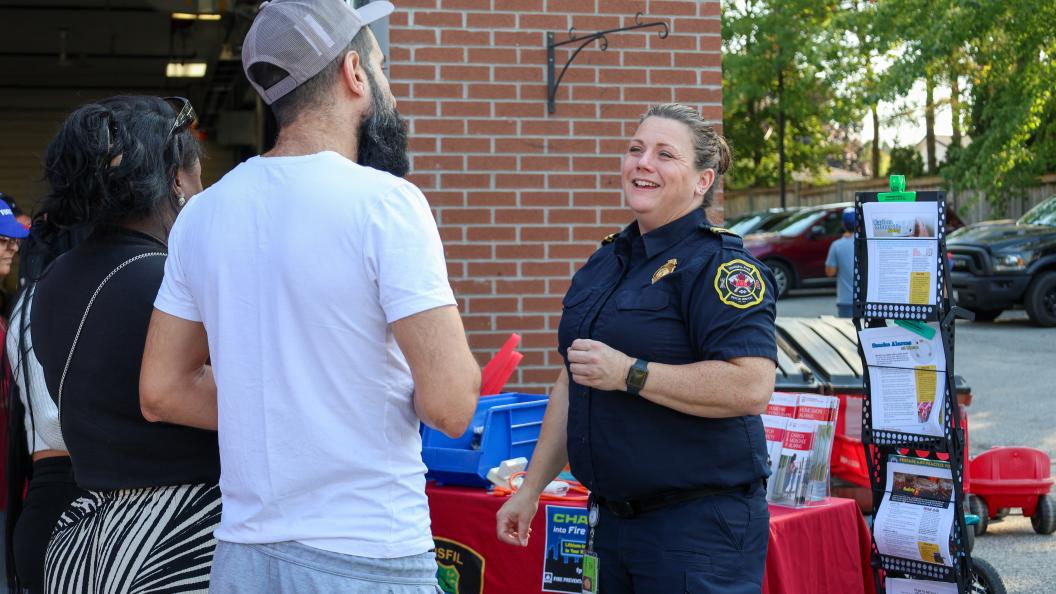 Fire safety officer talking to couple at outreach event