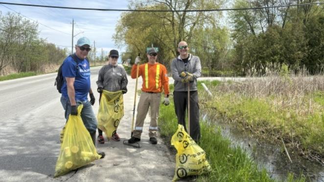 Group of people picking up roadside trash