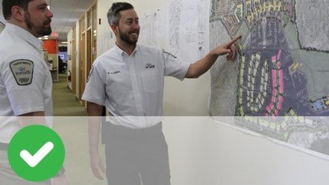 Two municipal law officers looking at a map