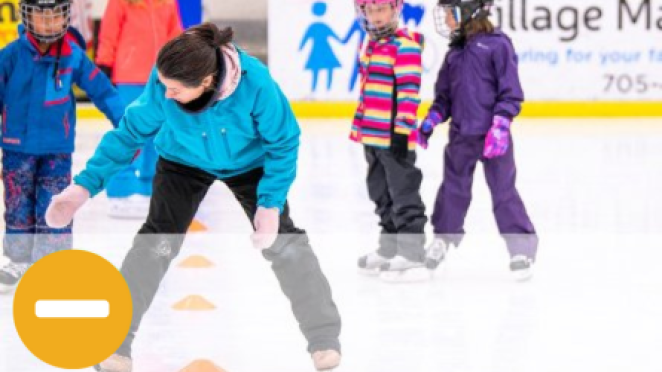 Skating instructor teaching young kids on arena ice