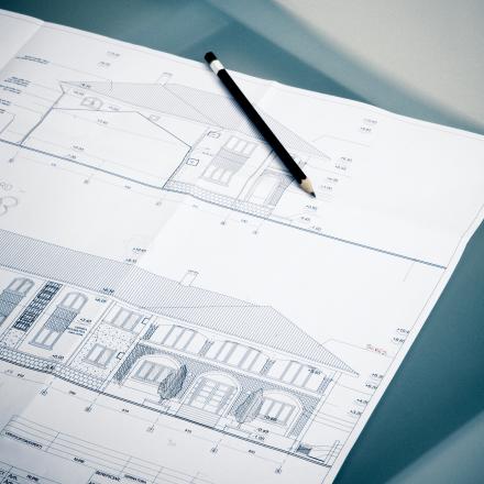 Blueprint drawing of a house with a pencil
