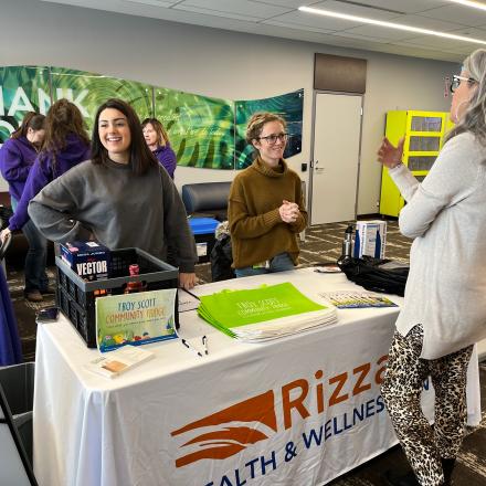 Two people at an information table providing resources to resident