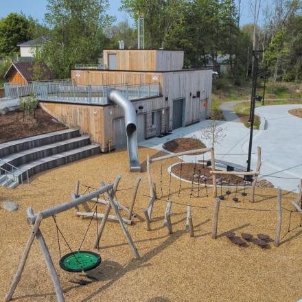 Aerial shot of park with large slide, natural playground elements and splash pad