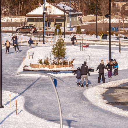 Aerial shot of park with large ice skating trail and people skating