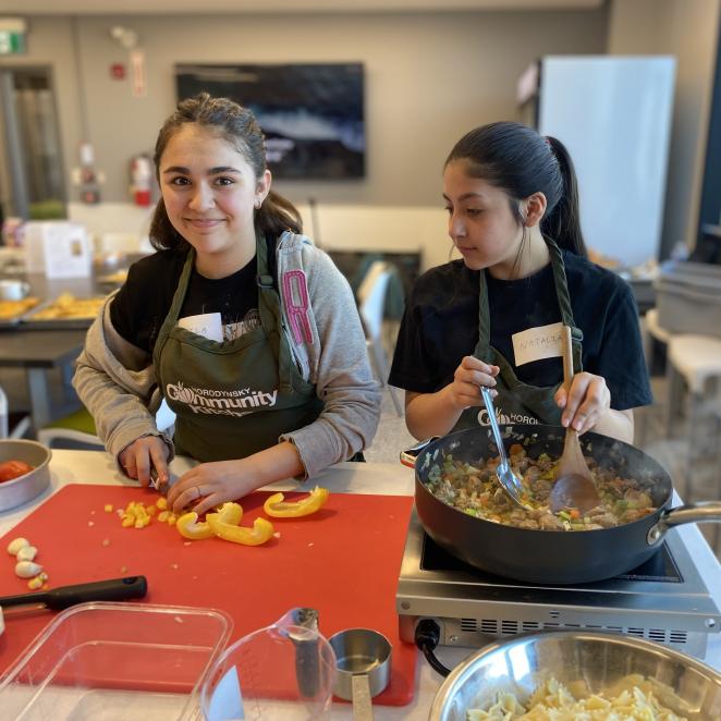 Two teen girls participating in cooking program