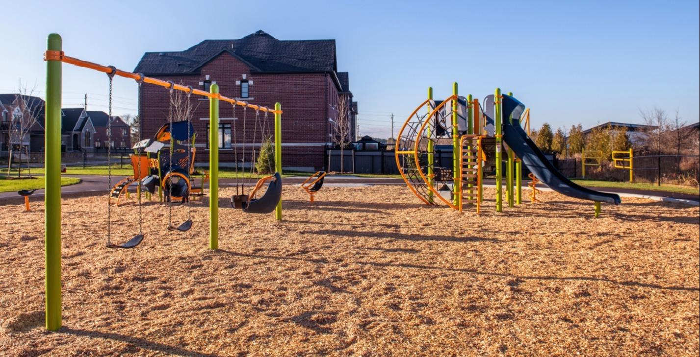 Playground with slides, swings, and other features in a suburban neighbourhood